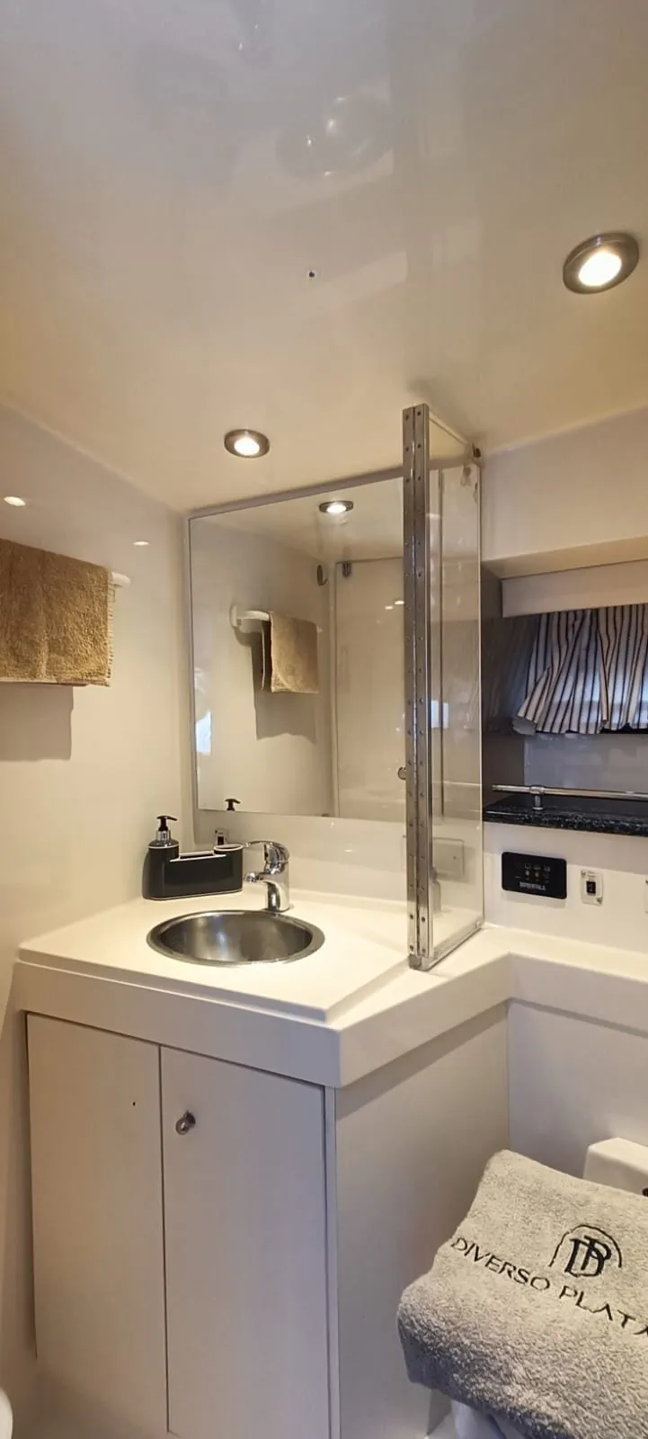 The ensuite bathroom, its round basin and mirror beside a glass shower stall